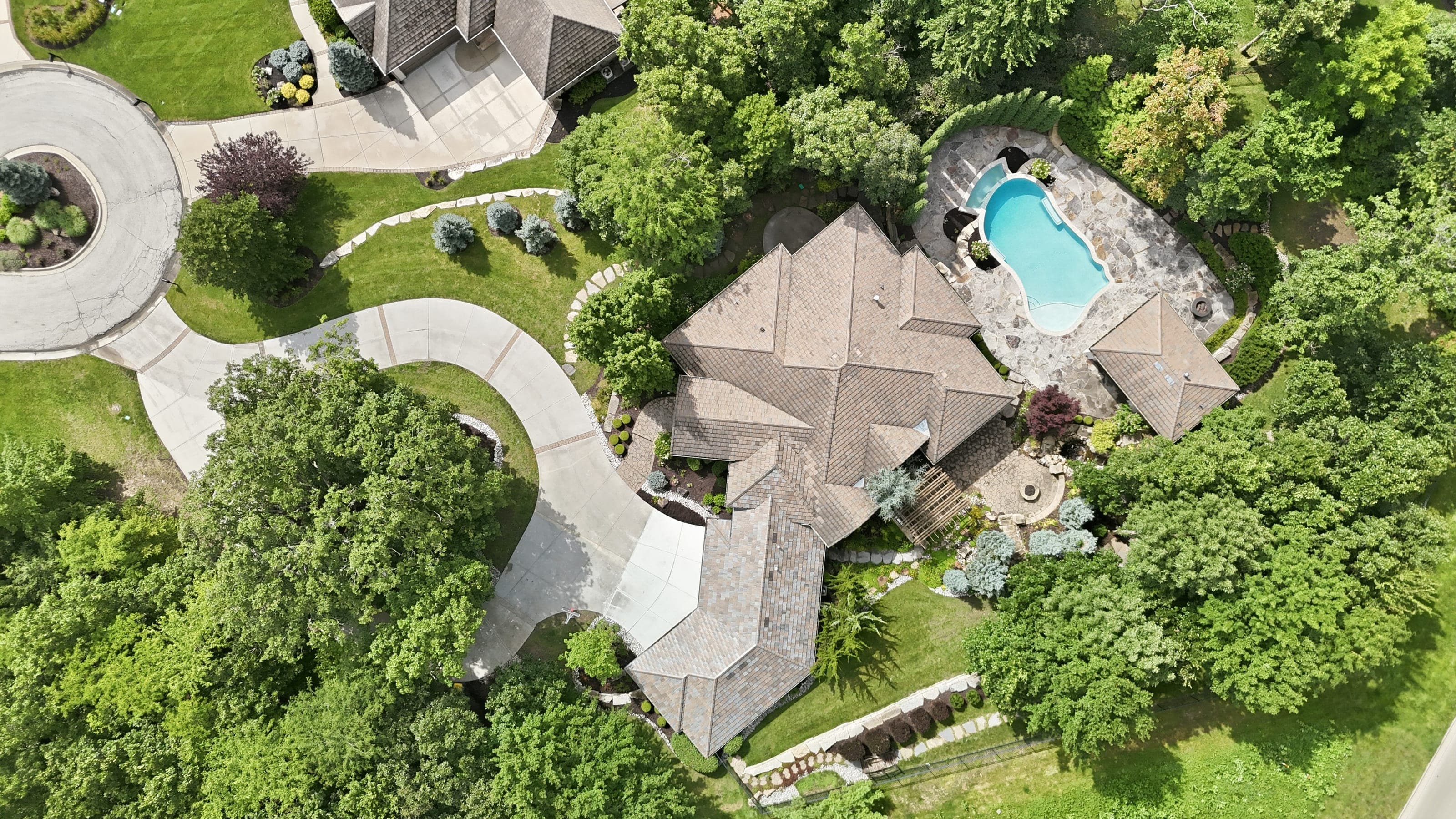 Overhead drone photo of a home with pool and circular driveway