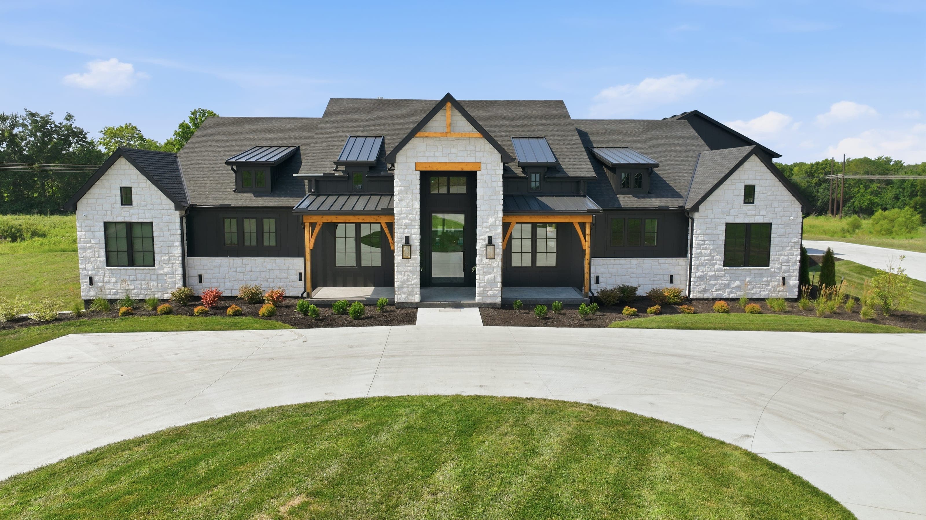 Elevated front elevation of a stone and black farmhouse