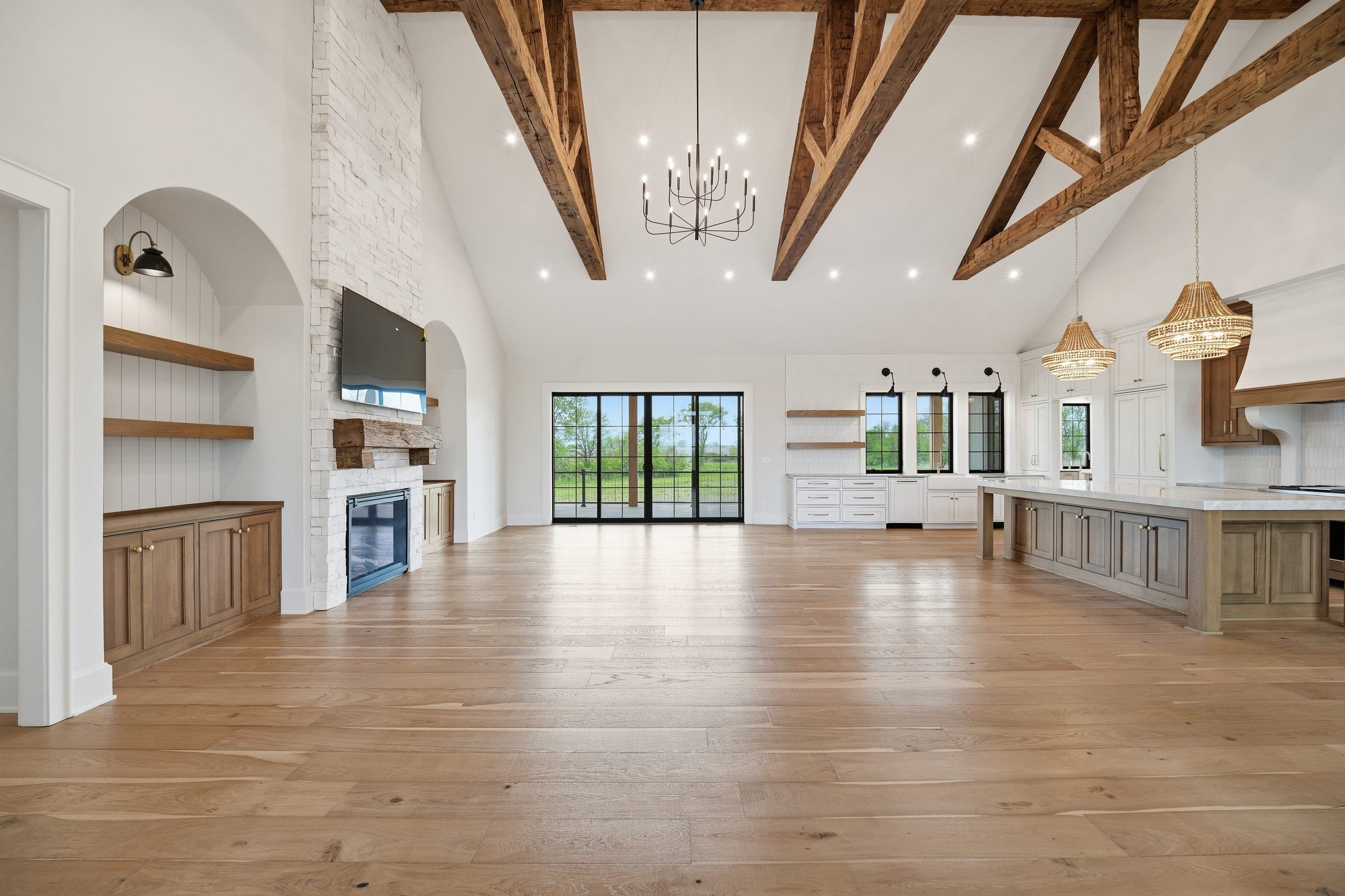 Vaulted great room with exposed timber trusses and stone fireplace