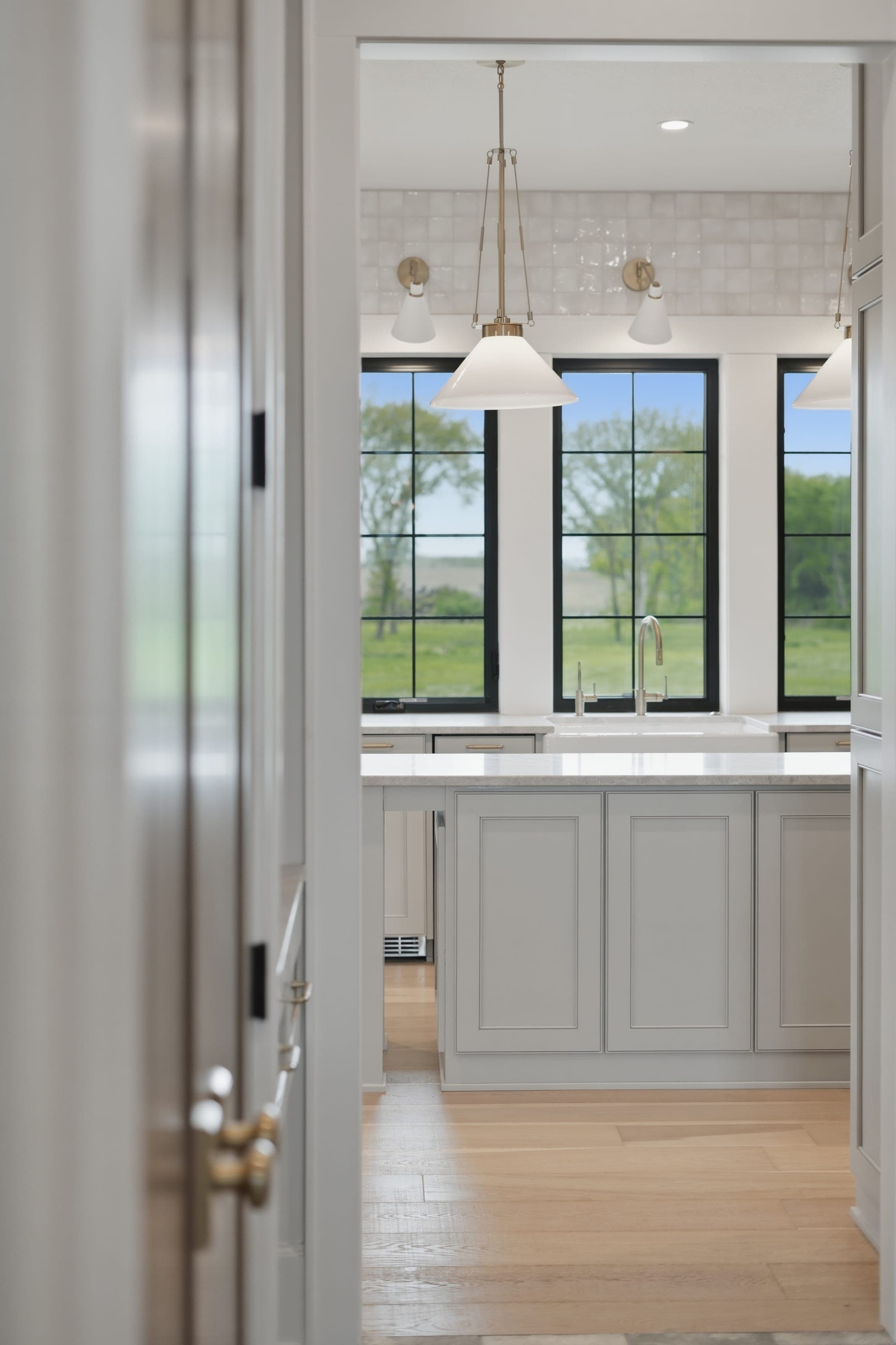View through a doorway into a kitchen with pendant lighting