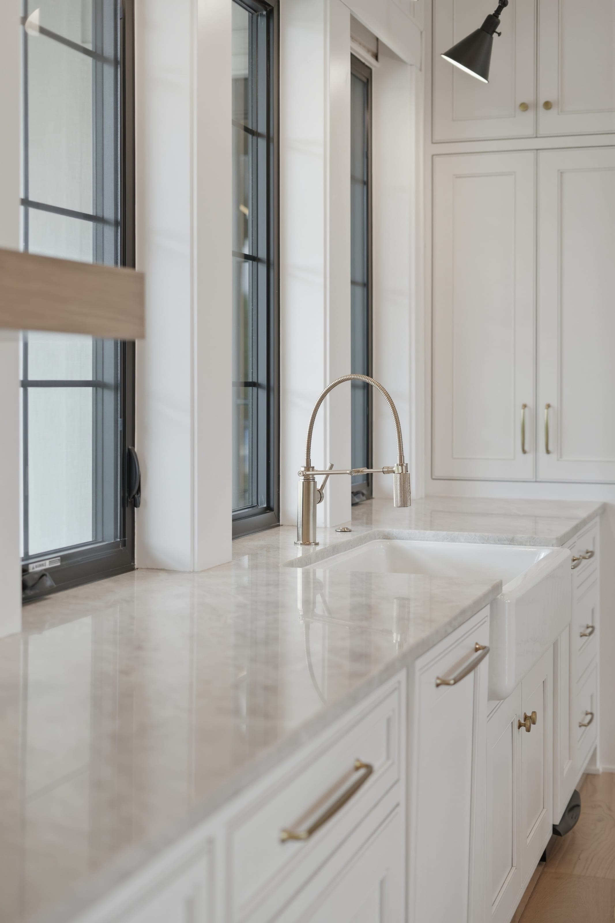 Prep kitchen with marble counter, farmhouse sink and brass fixtures