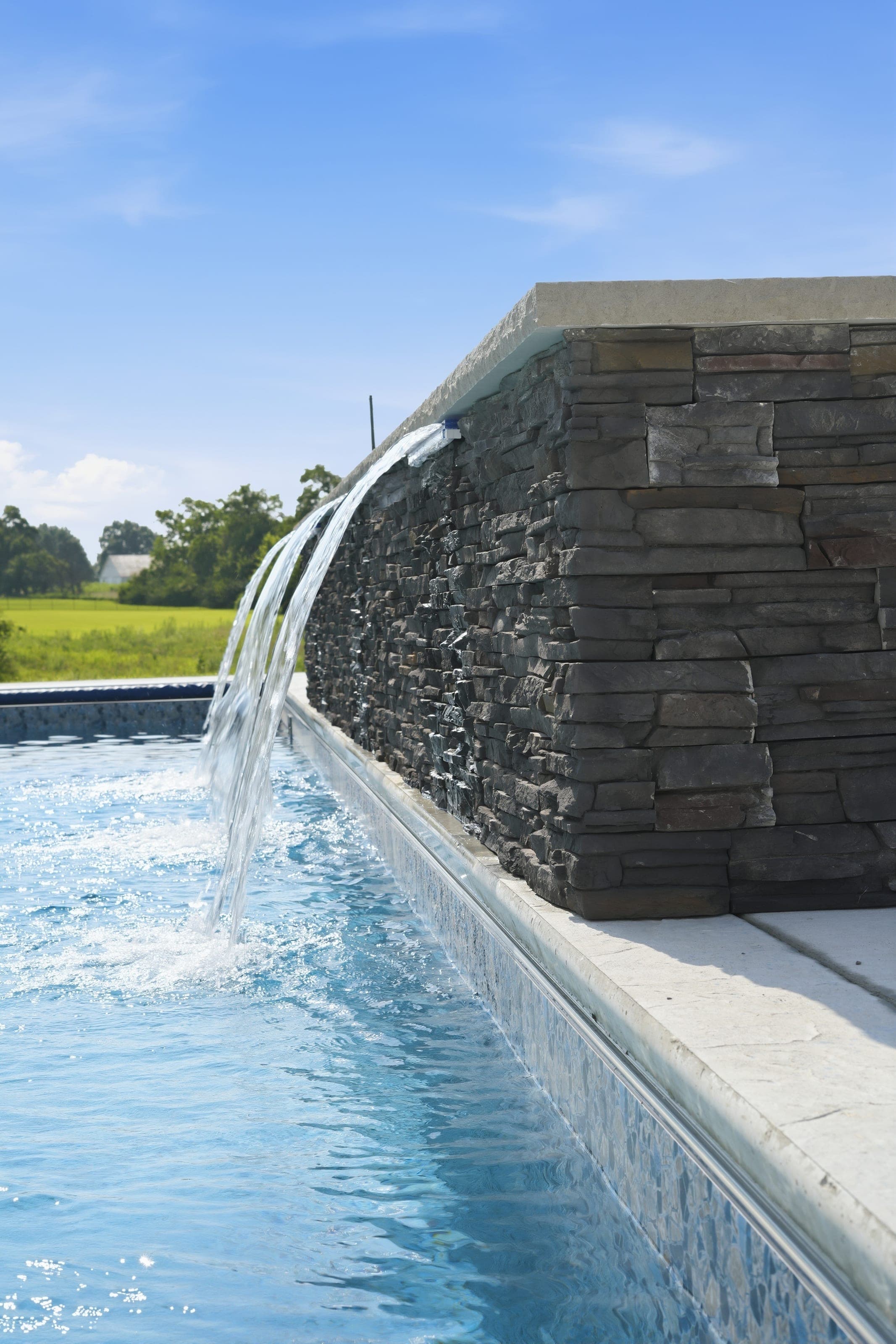 Pool with a stacked stone waterfall wall