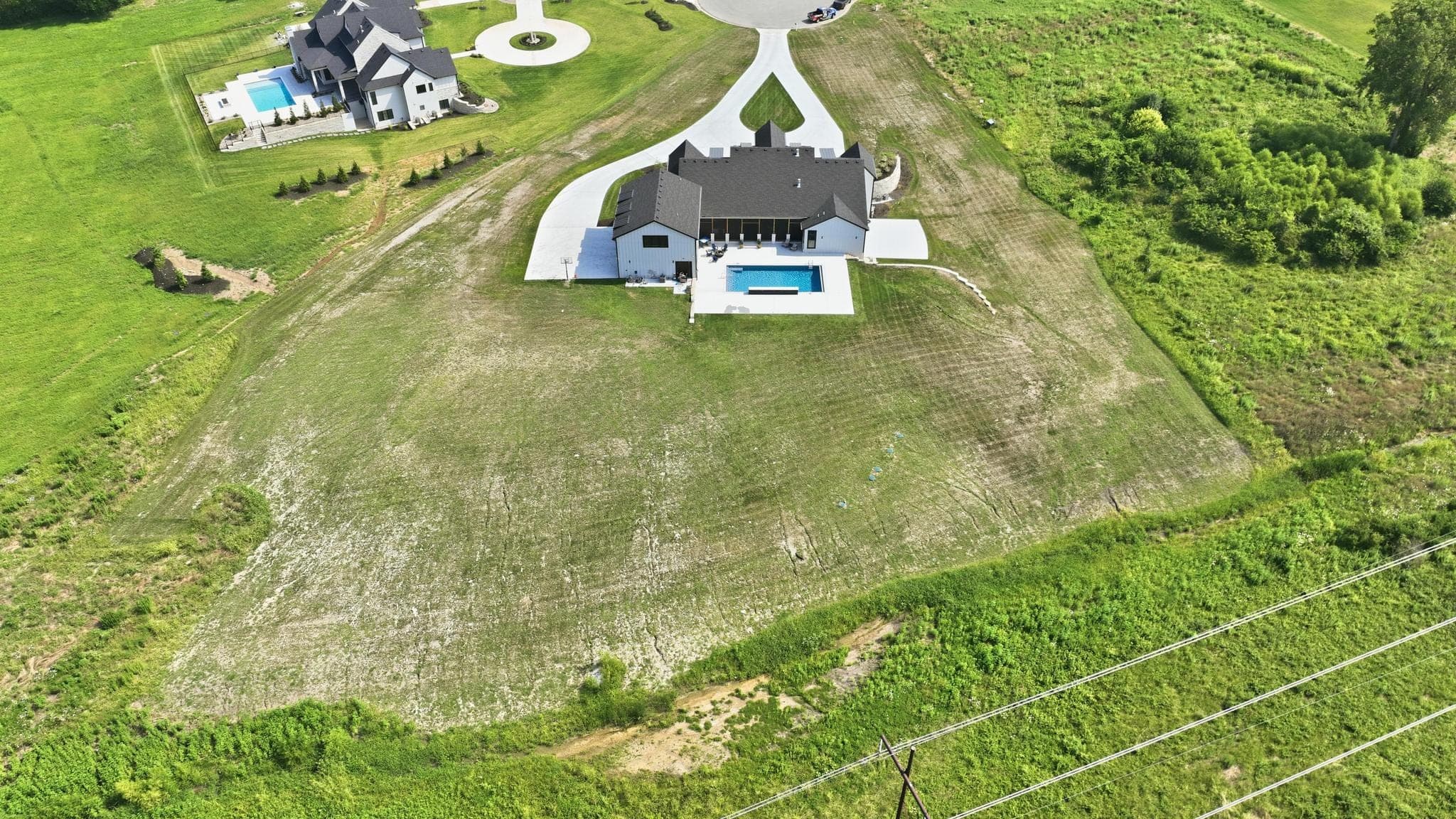 High aerial of the rear of the property and open acreage