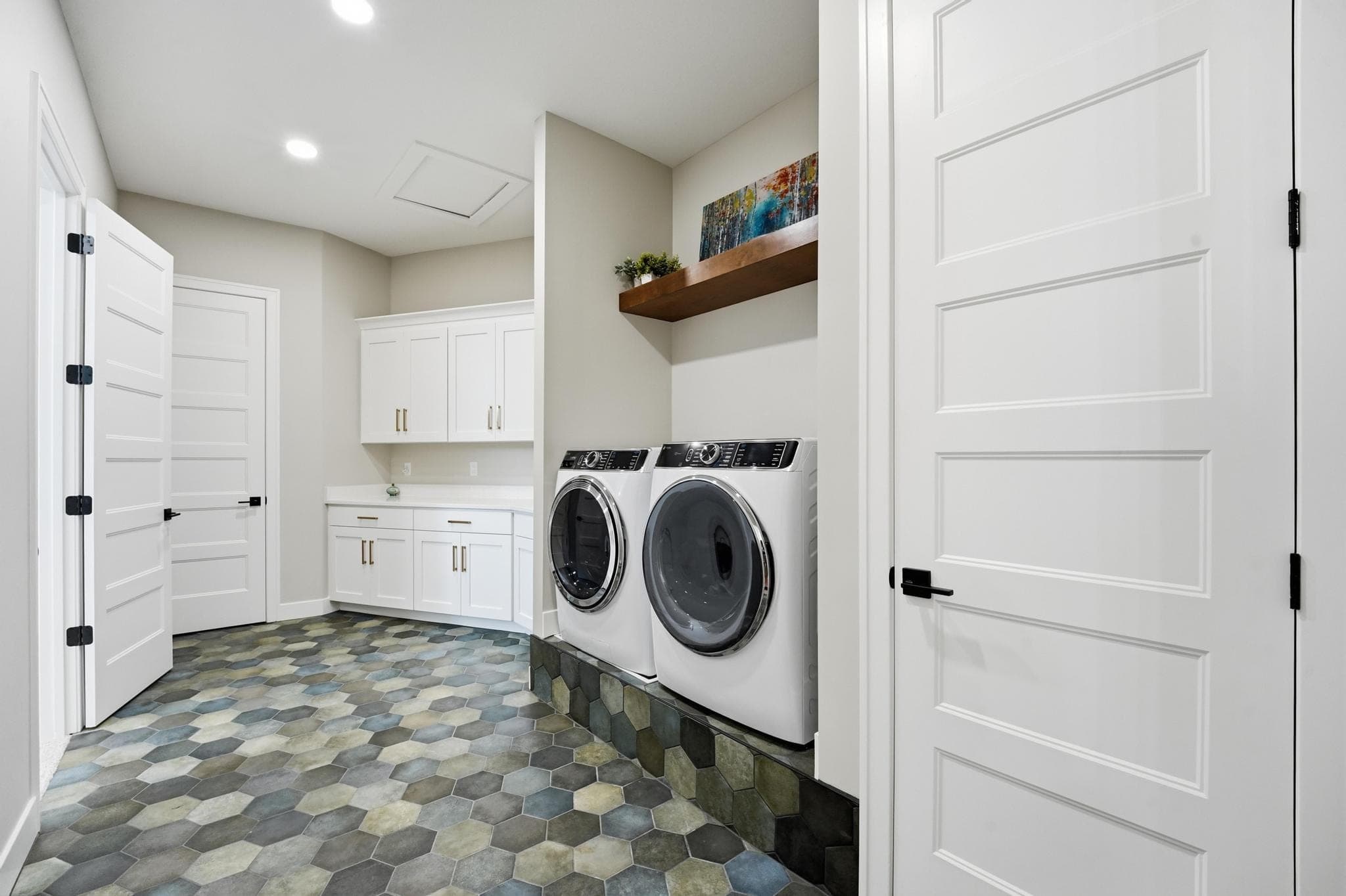 Laundry room with washer and dryer and patterned tile floor