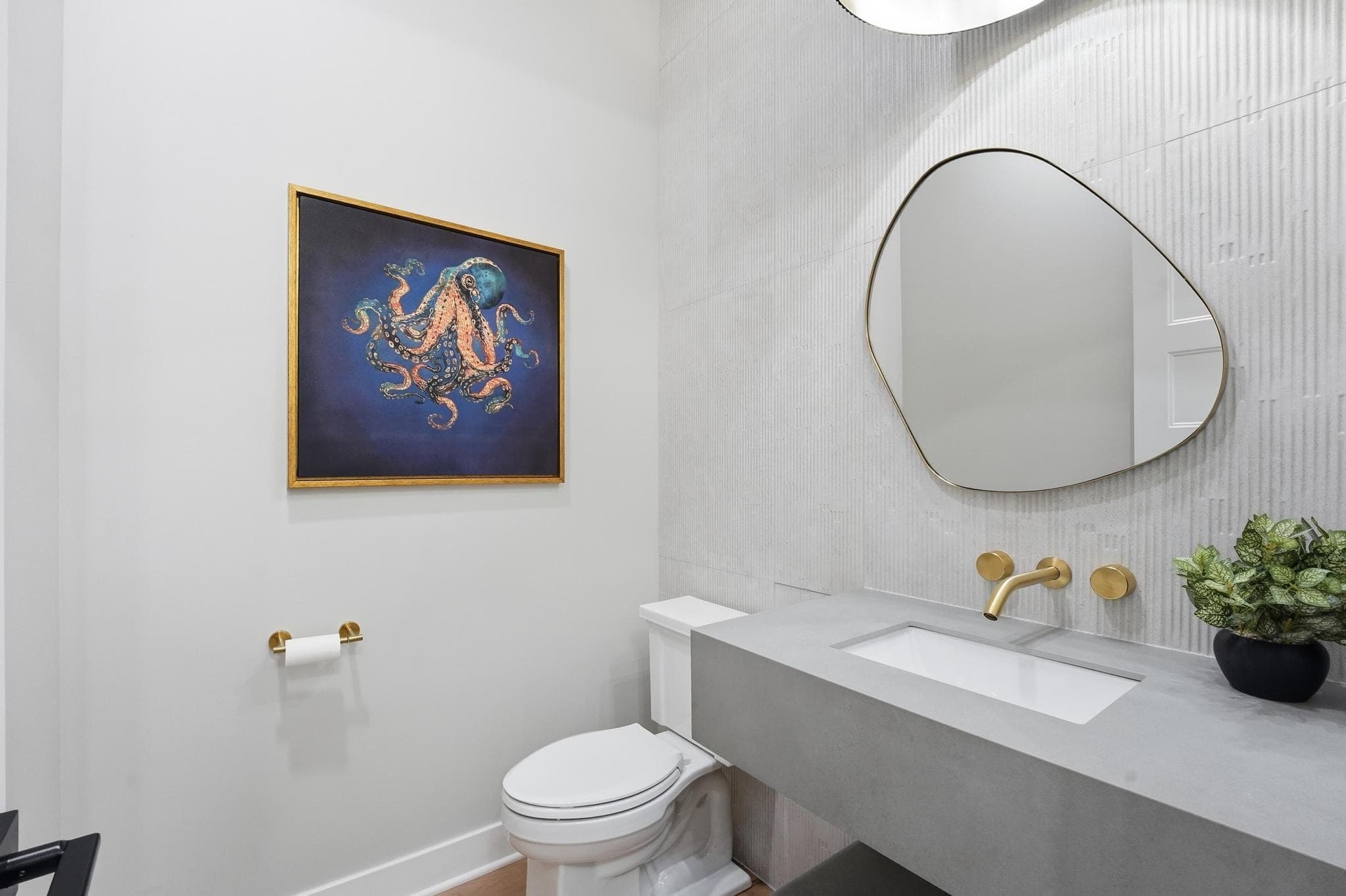 Powder bath with a floating concrete vanity and organic mirror