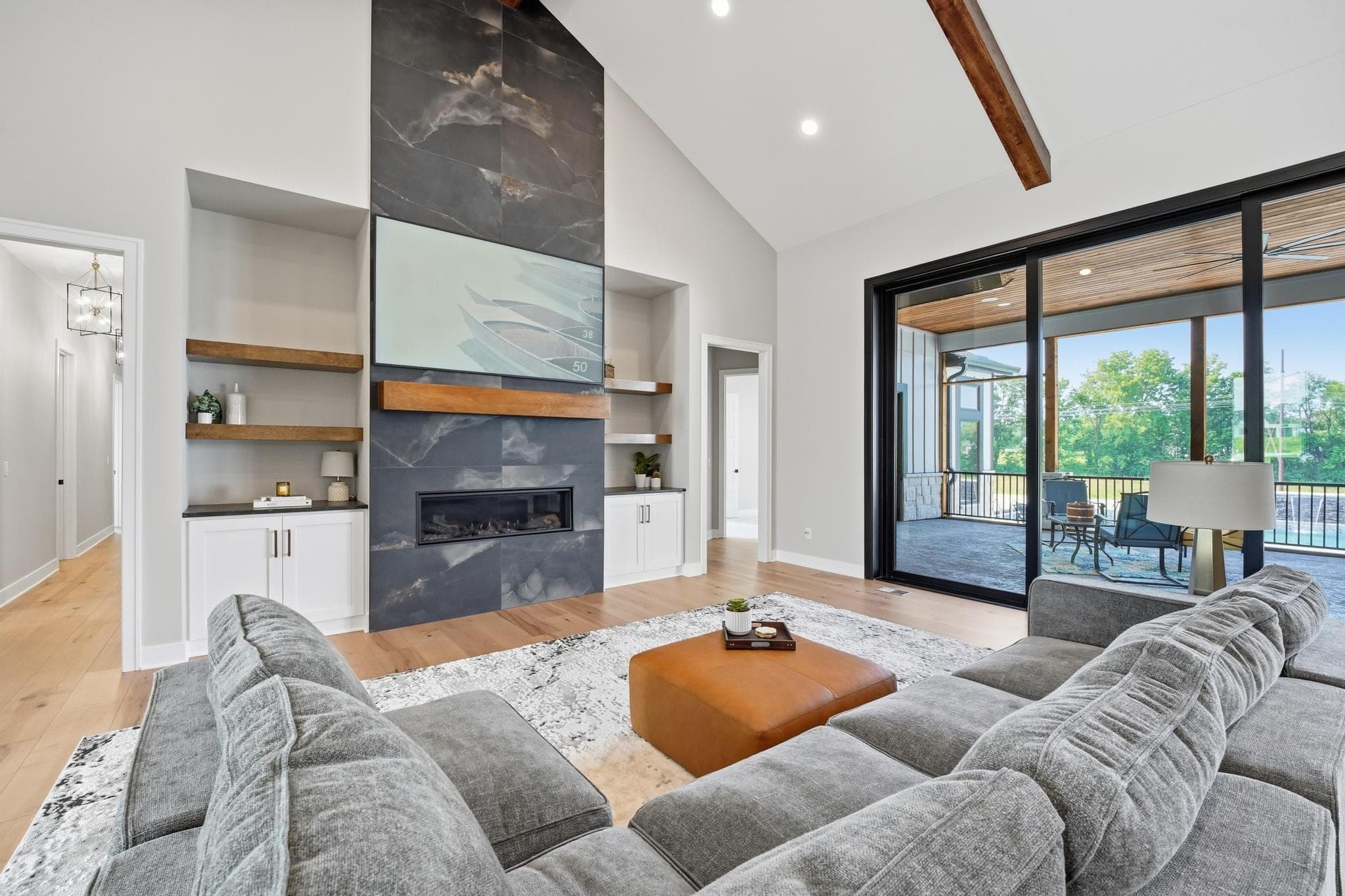 Living room with a grey sectional, slate fireplace and sliding patio doors