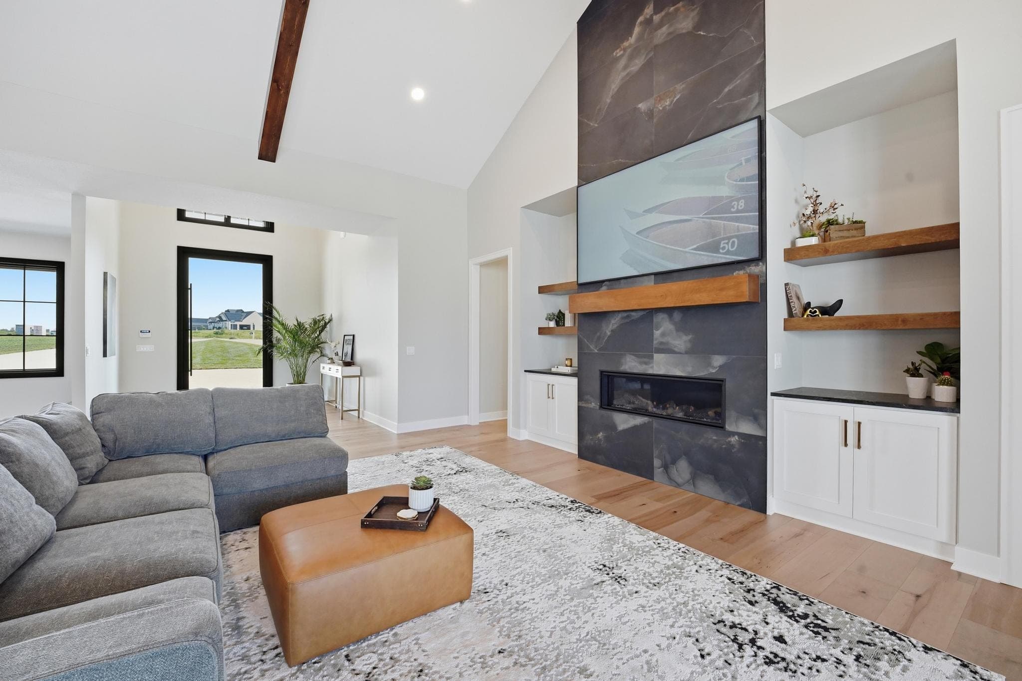 Living room seating facing the slate fireplace and floating shelves