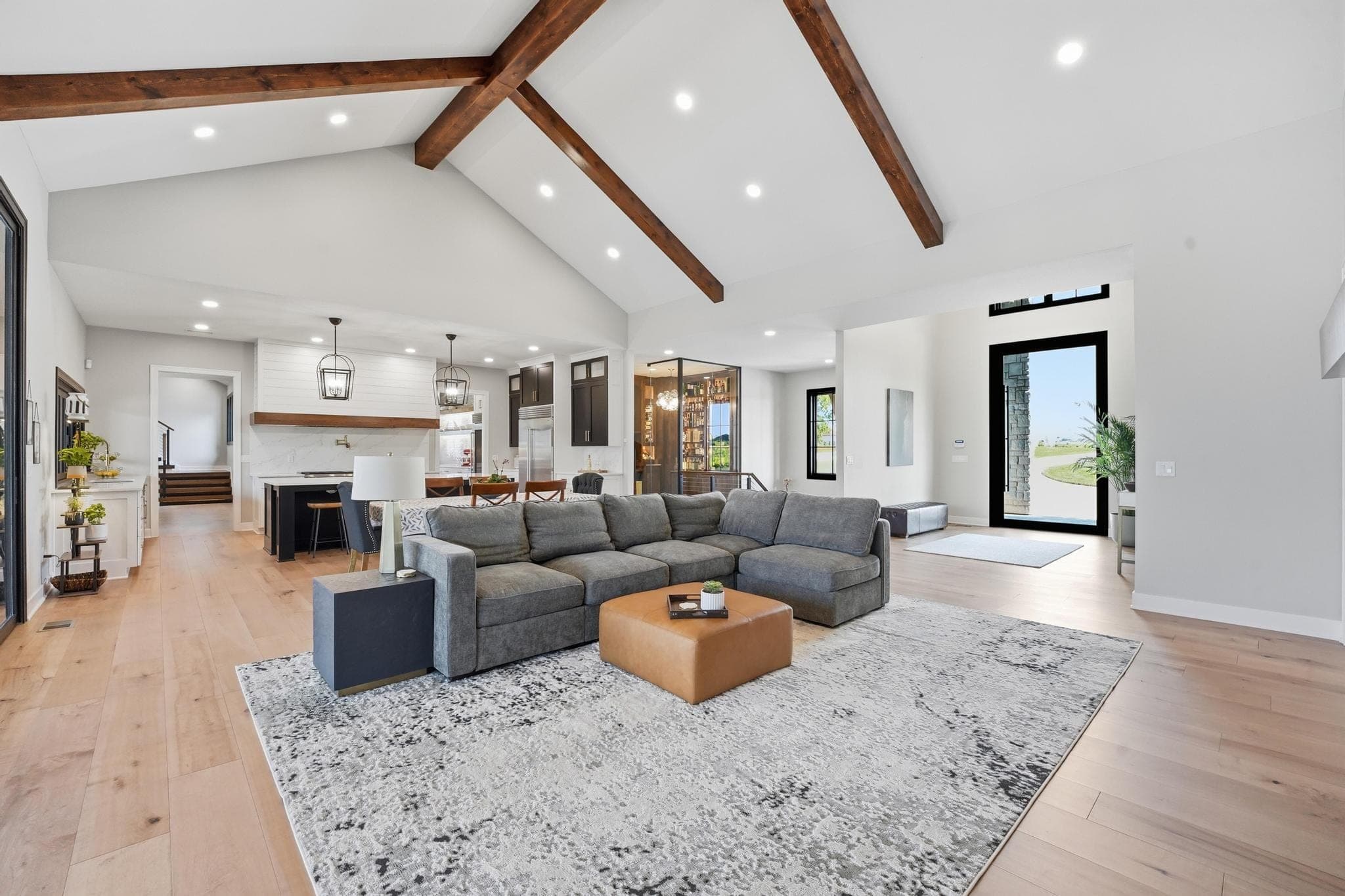 Great room seen from the kitchen under exposed beams