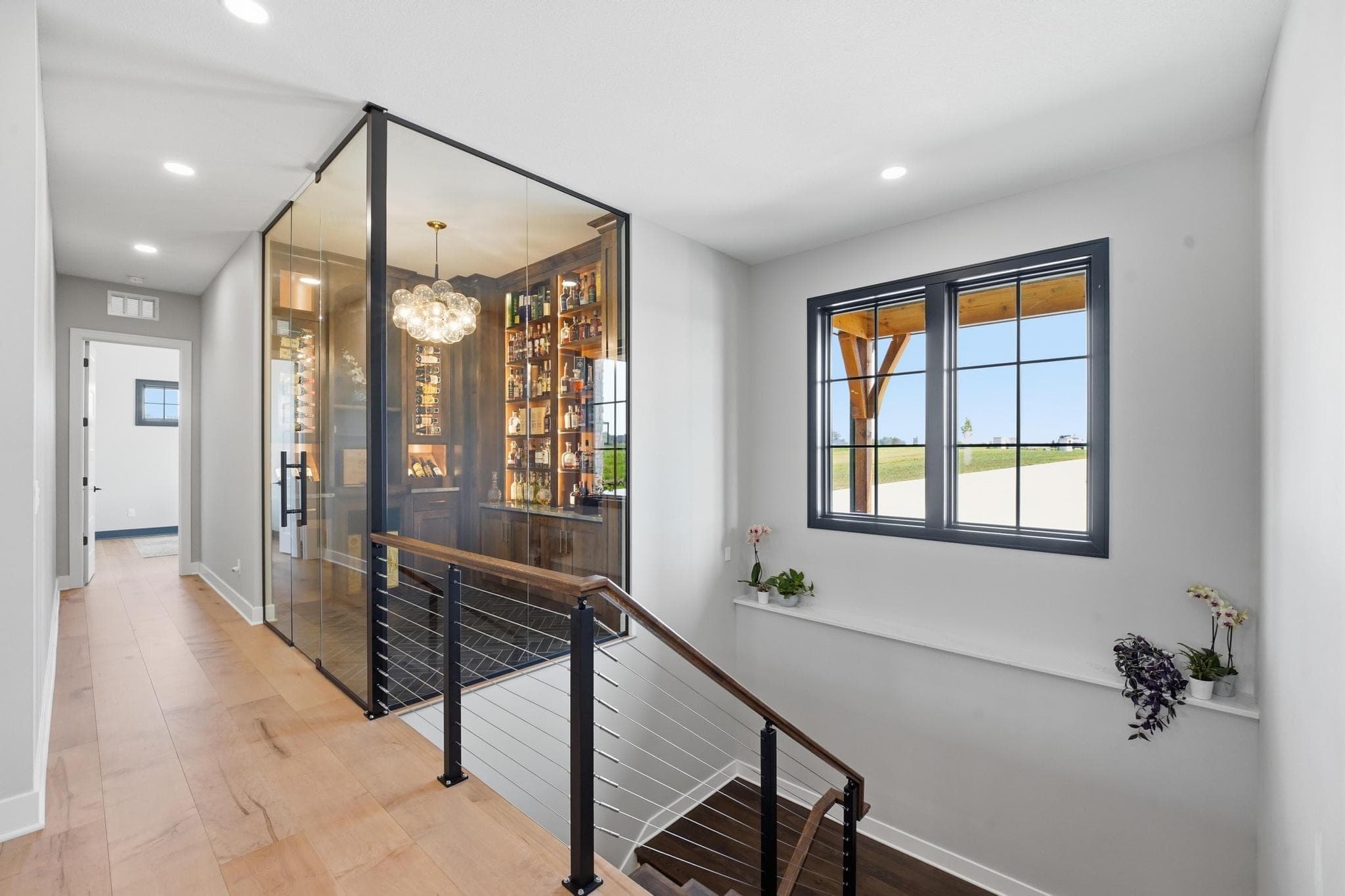 Glass-walled wine room beside the staircase