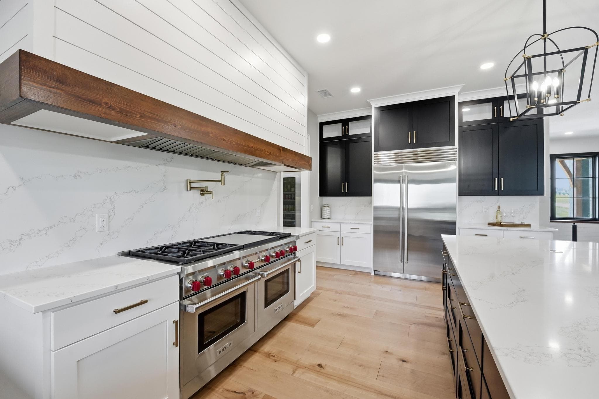 Range wall with paneled refrigerator and marble backsplash