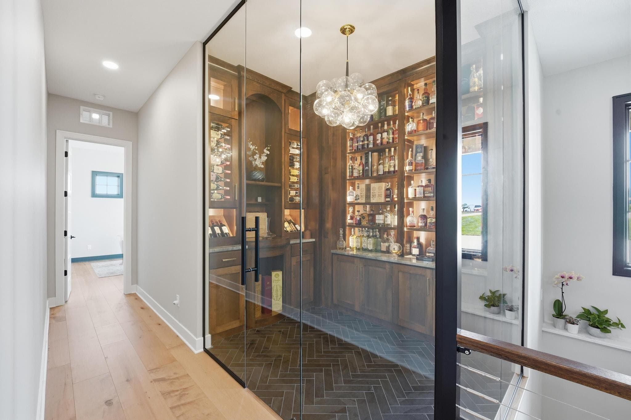 Glass wine room with wood shelving off the hall
