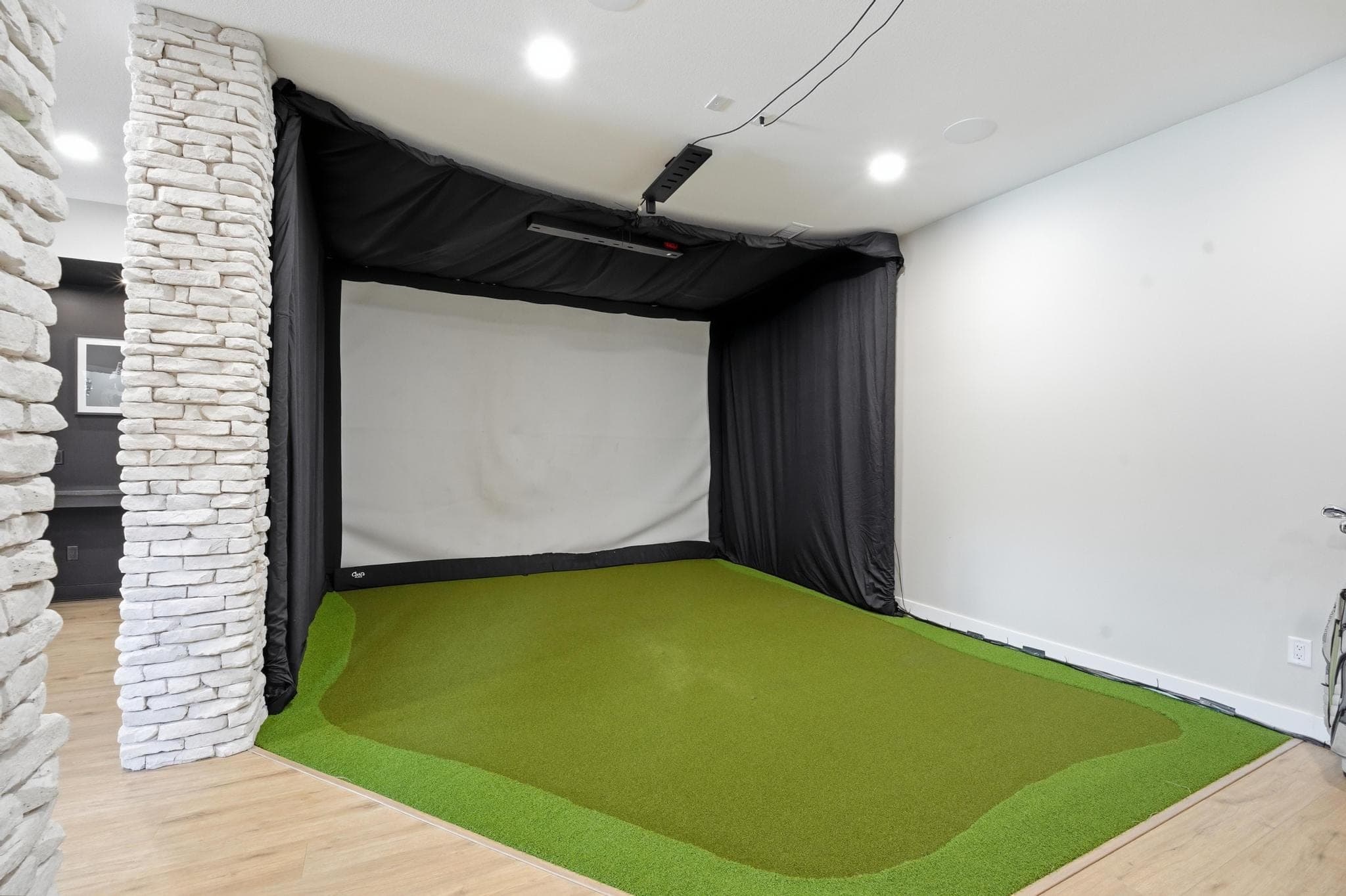 Golf simulator bay with stone surround