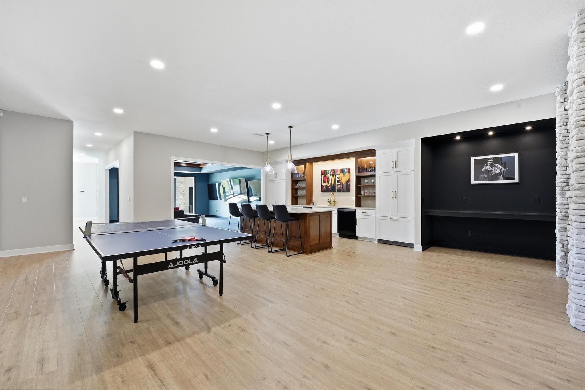 Lower level rec room with a ping-pong table and bar beyond