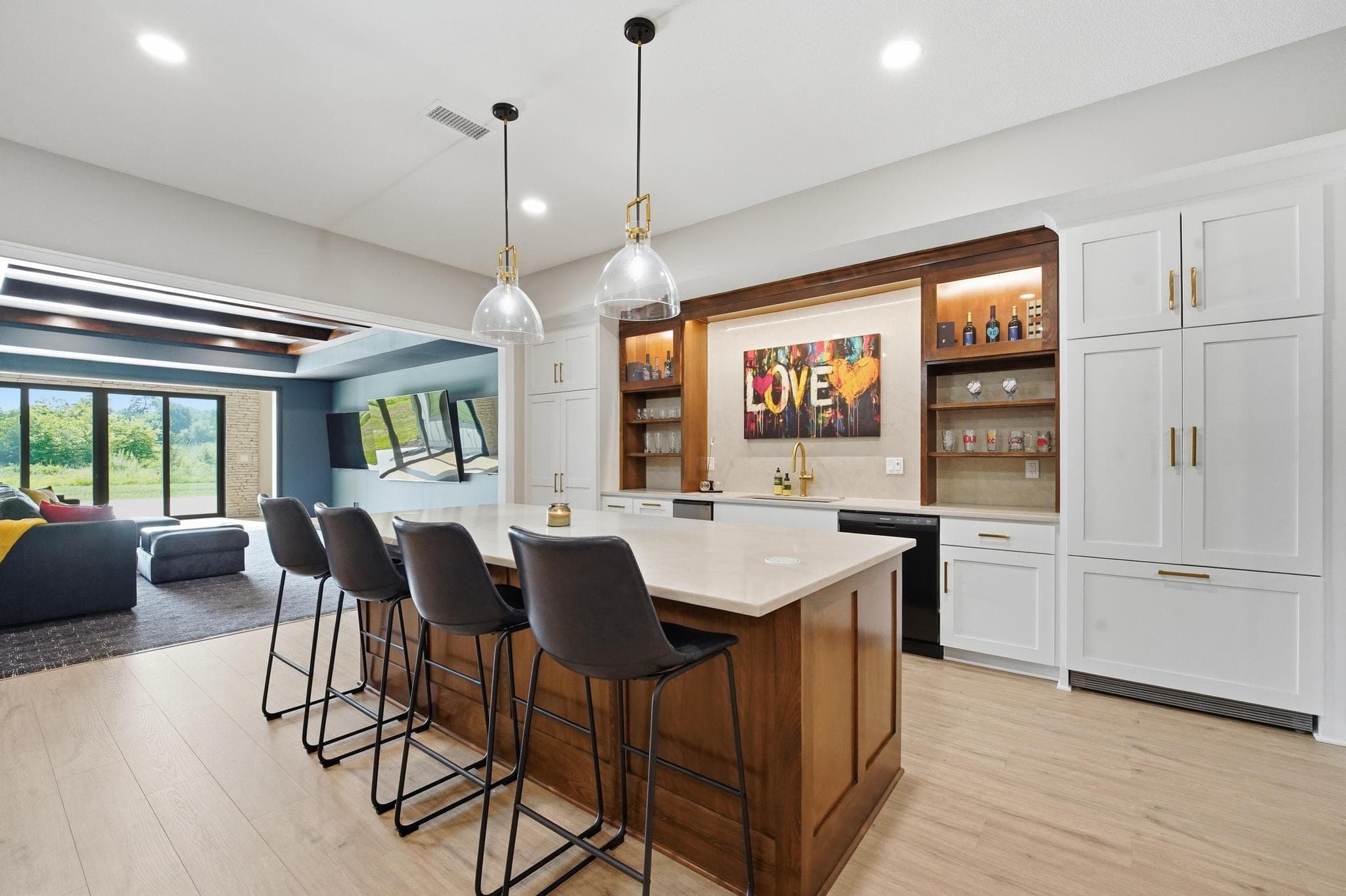 Lower level bar with island seating and backlit shelving
