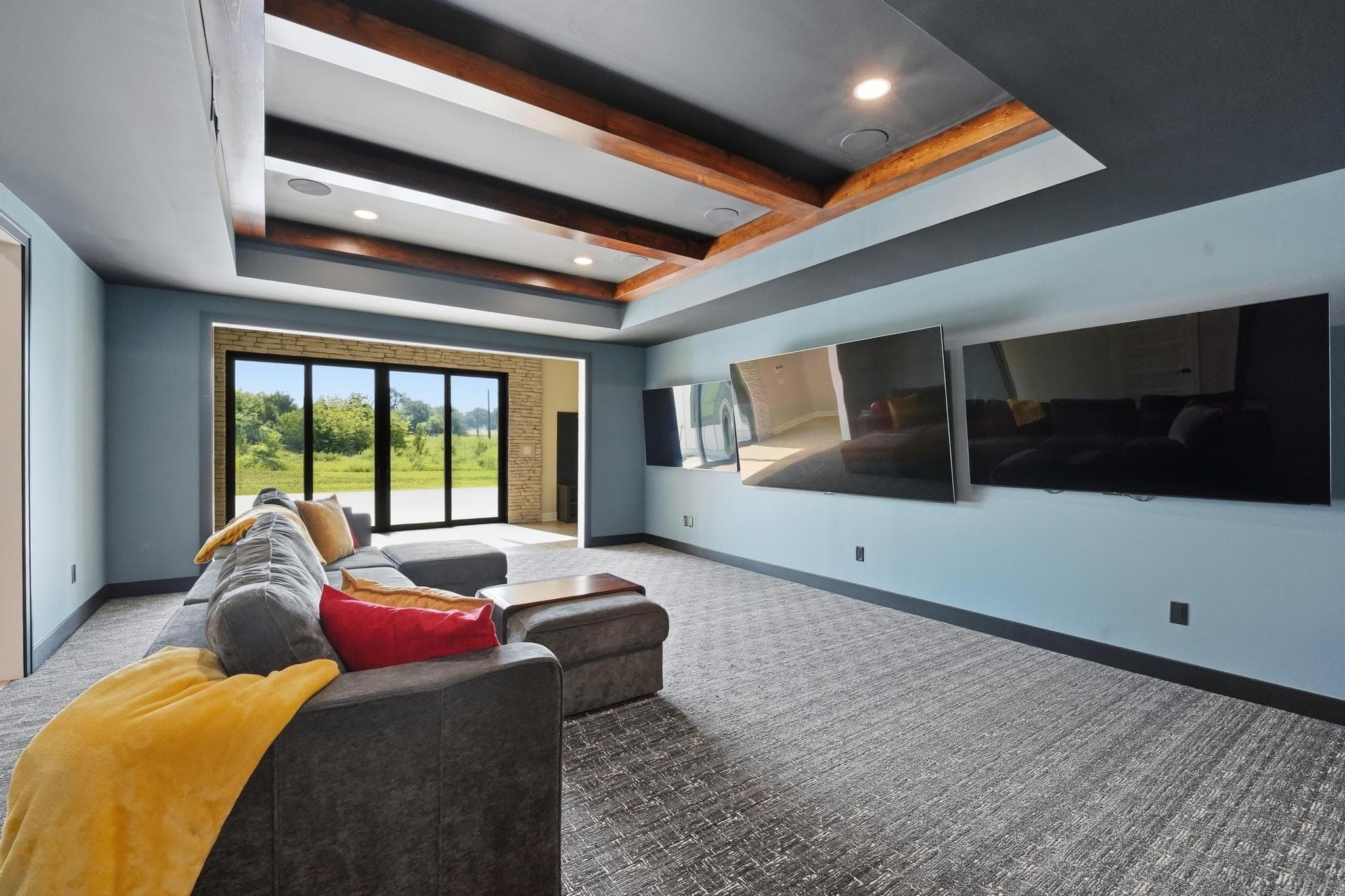 Media room with three screens and a coffered ceiling