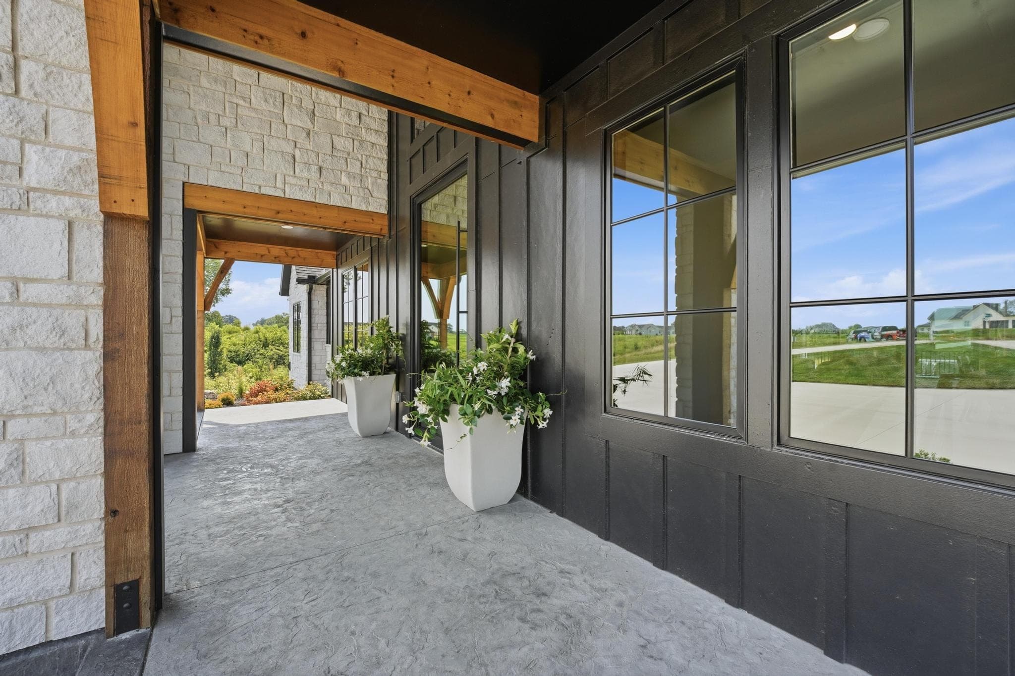 Covered front porch with stone walls, timber posts and planters