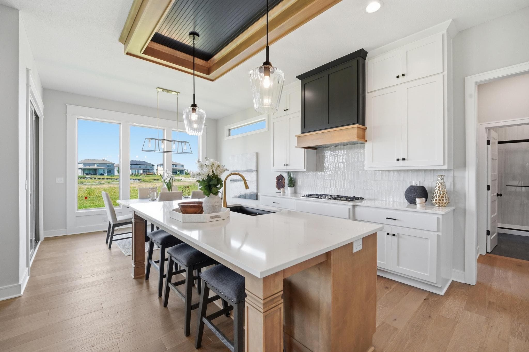 Kitchen with a wood island and white cabinetry