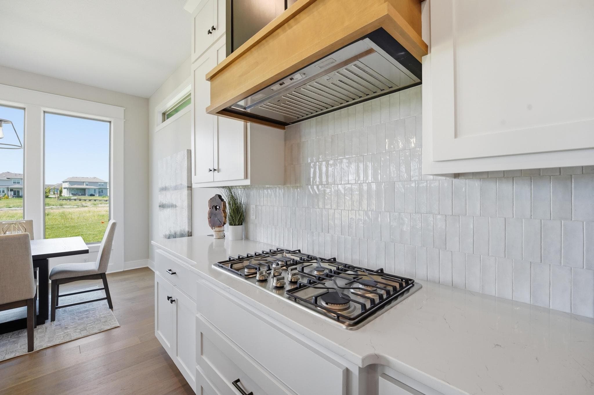 Gas range with tile backsplash and wood hood